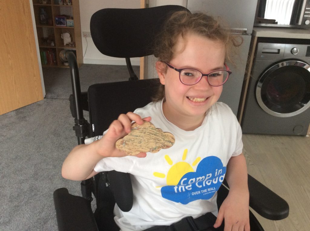 Young girl in wheelchair holding craft in Camp in the Cloud t-shirt