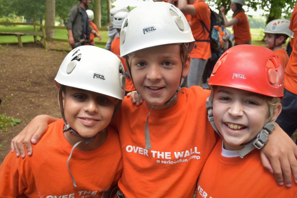 Group of young campers having fun and smiling at over the wall residential camp