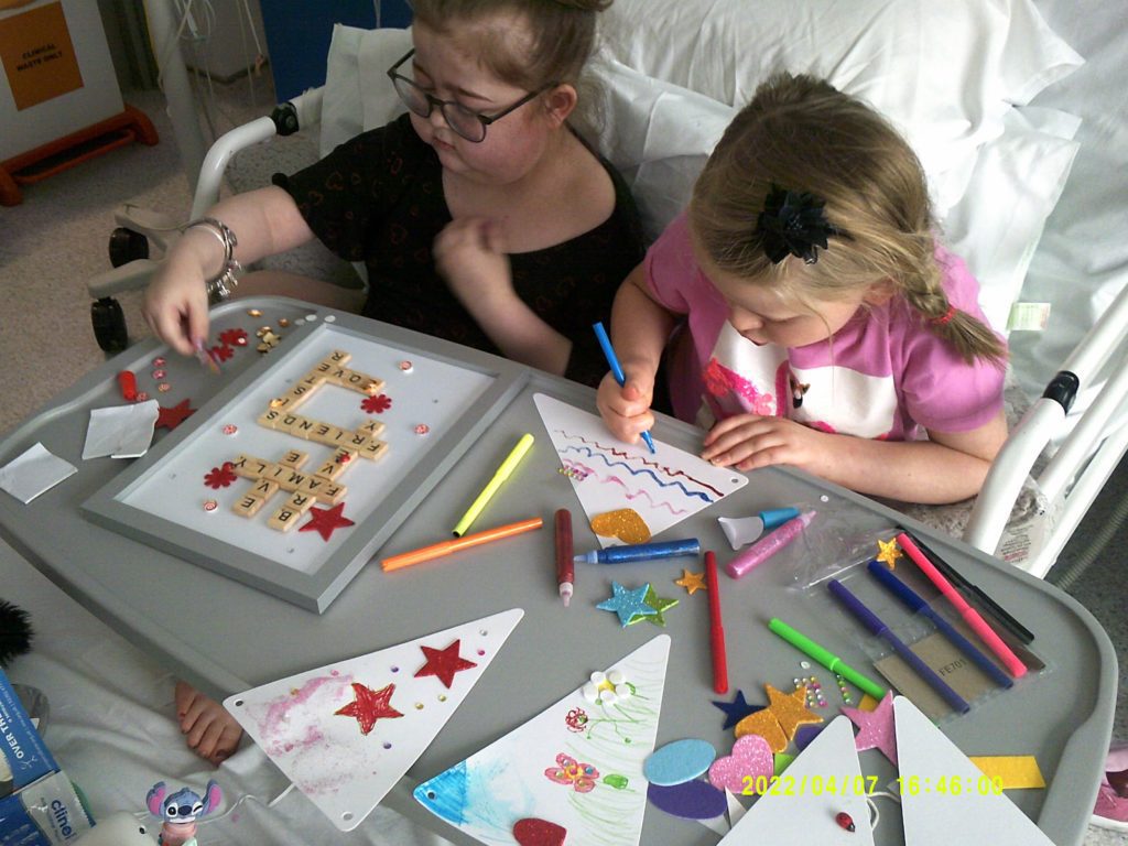 Two young girls in a hospital bed taking part in an Over The Wall Outreach Programme