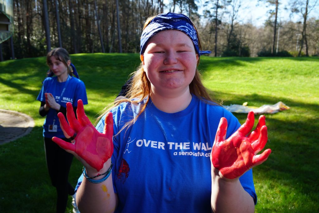 happy girl at camp with painted hands