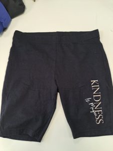 Black shorts with "Kindness is magic" on front