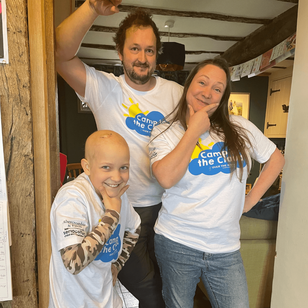 A family of three pose in their Camp in the Cloud t-shirts.