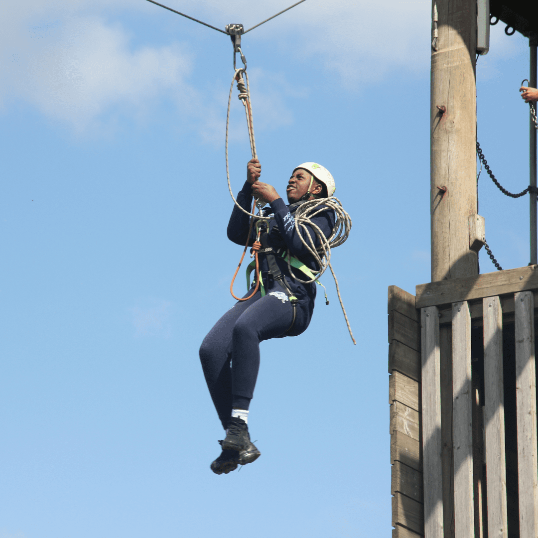 A teenage boy whizzes down a zipwire