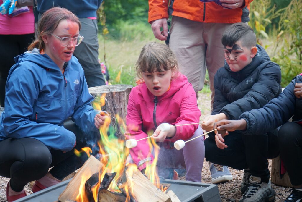 campers toasting marshmallows around the fire