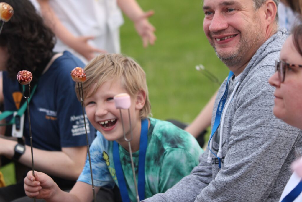 camper and parent toasting marshmallows