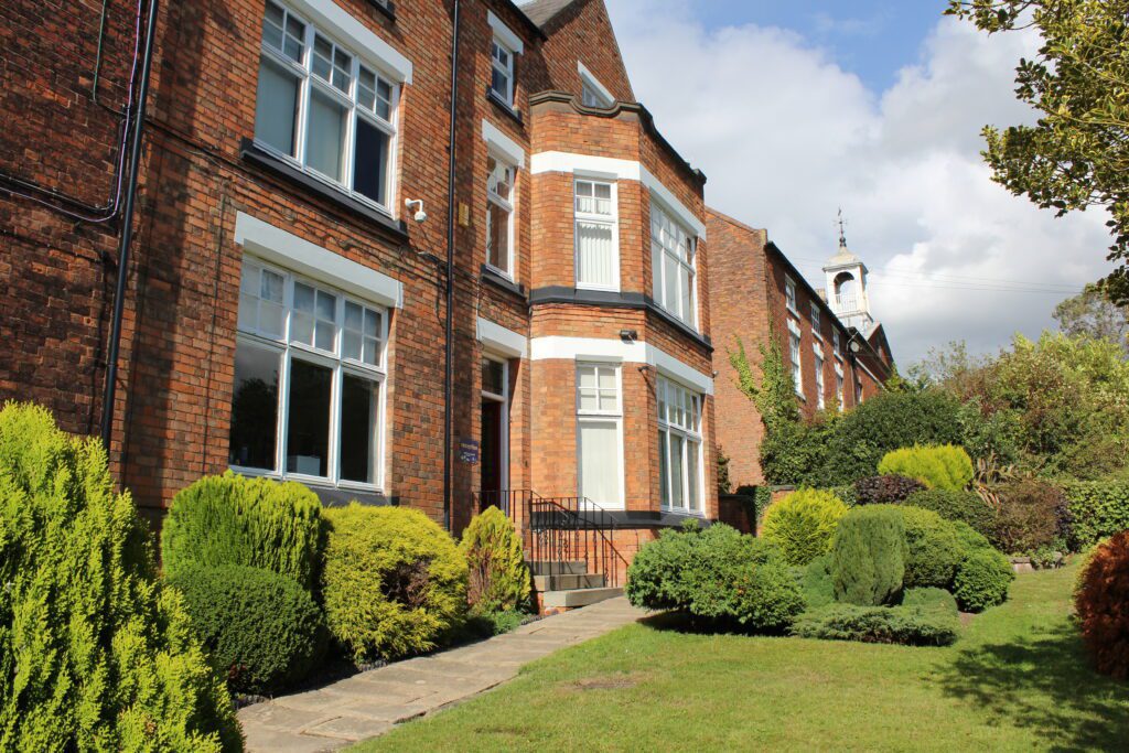 Red brick school building in beautiful grounds