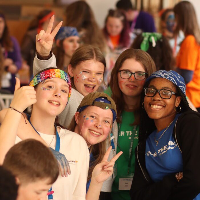 Large group of children smiling in Over The Wall Camp t-shirts