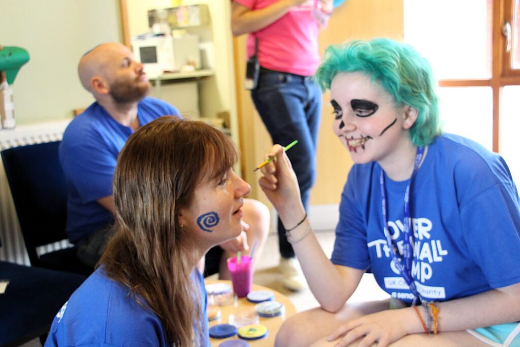Tori having her face painted by a camper
