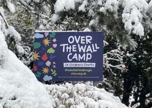 Over The Wall Camp sign in a snowy backdrop