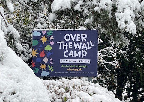 Over The Wall Camp sign in a snowy backdrop