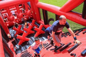 Man and young boy climbing an inflatable ladder