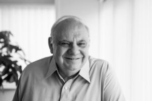 Black and white photo of an older gentleman in a shirt, smiling