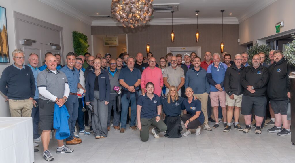 Large group of people smiling and posing for a photo to celebrate a charity Golf Day