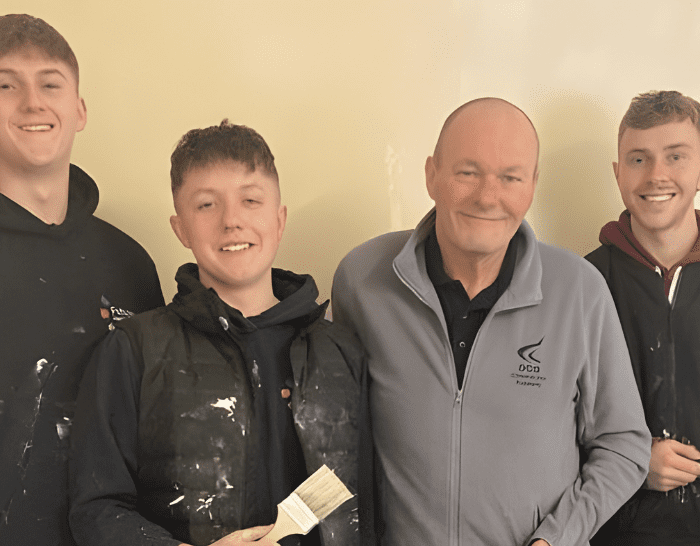 Group of Derby College apprentices holding painting items