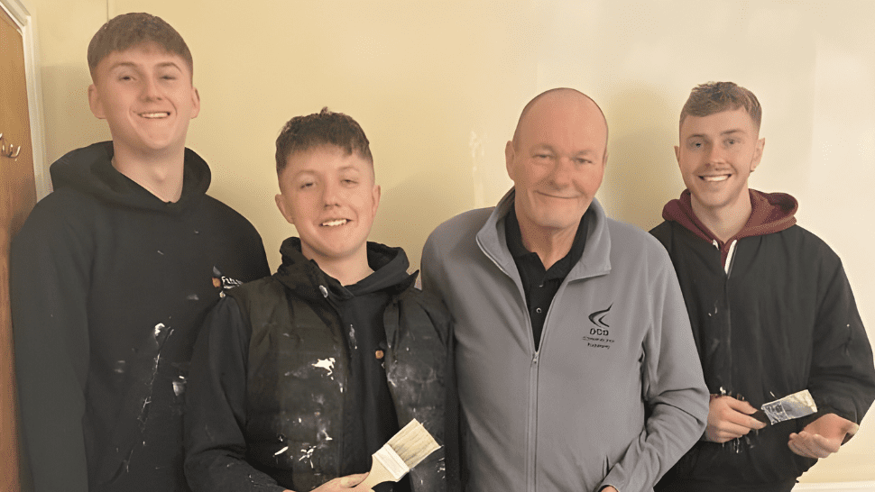 Group of Derby College apprentices holding painting items