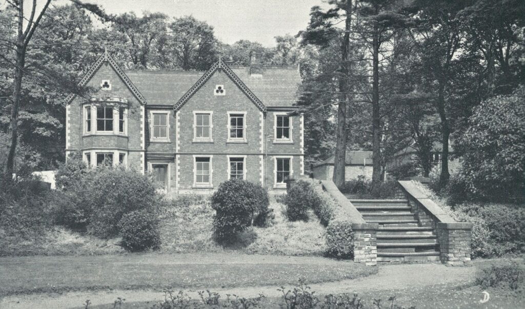 Black and white photo of an old school building with grounds