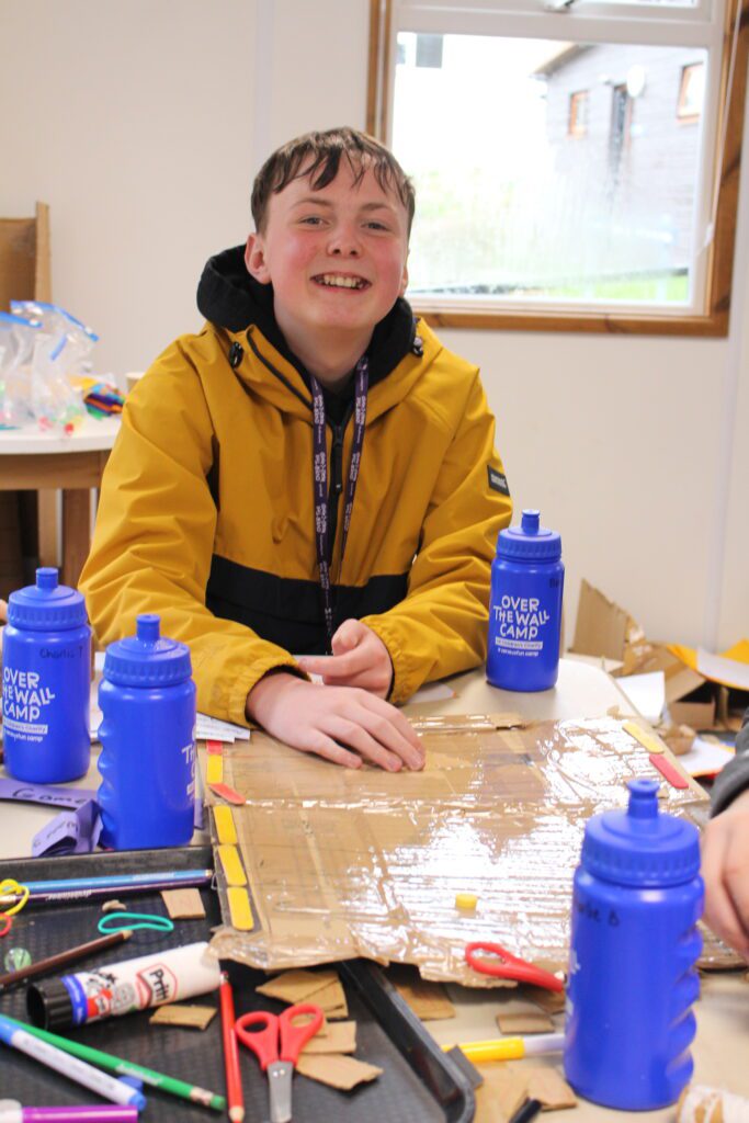 Ben sat down smiling at the camera in a yellow mac